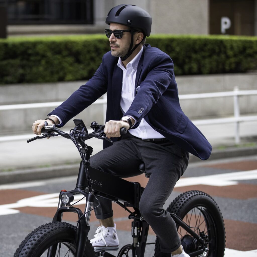 電動自転車MOVEをヘルメットをかぶって都内の道路を優雅に走る外人さん