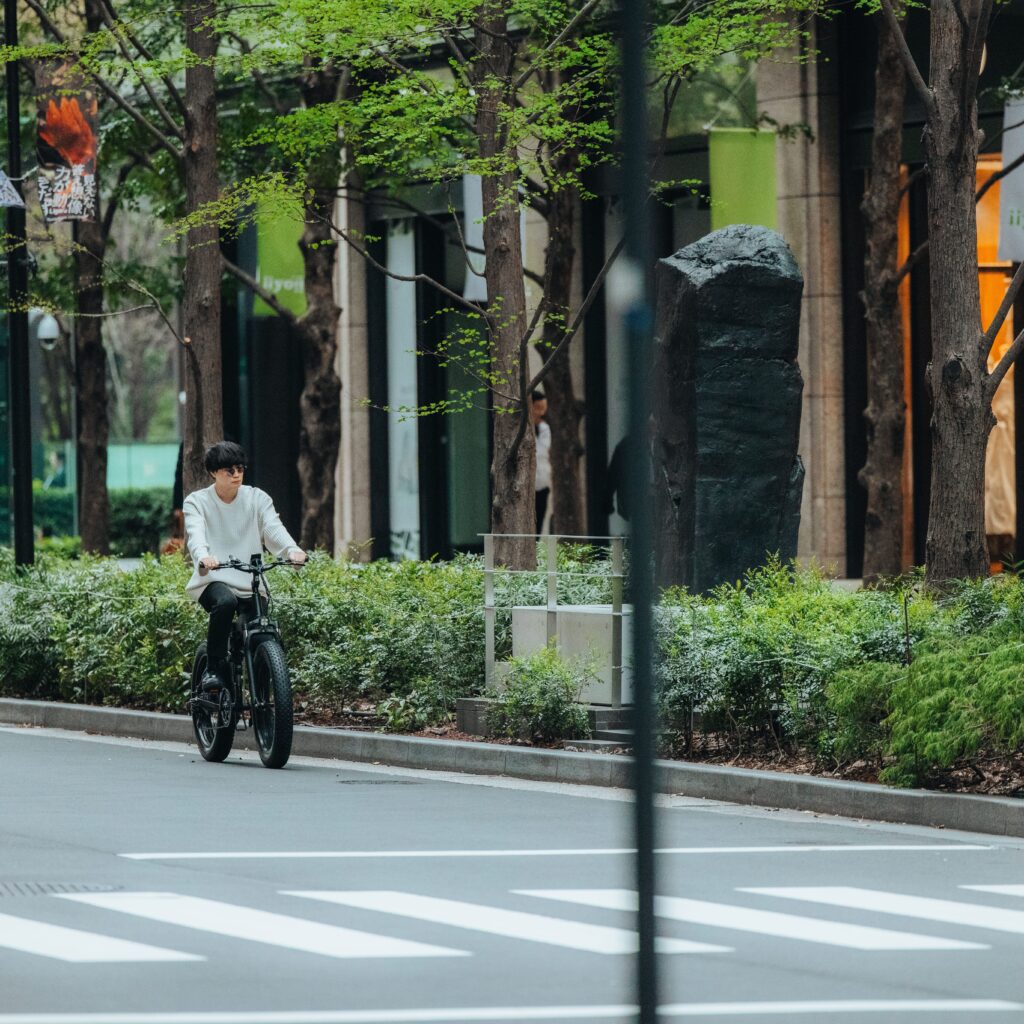 電動自転車MOVEを都内のおしゃな街路で走らせている男性