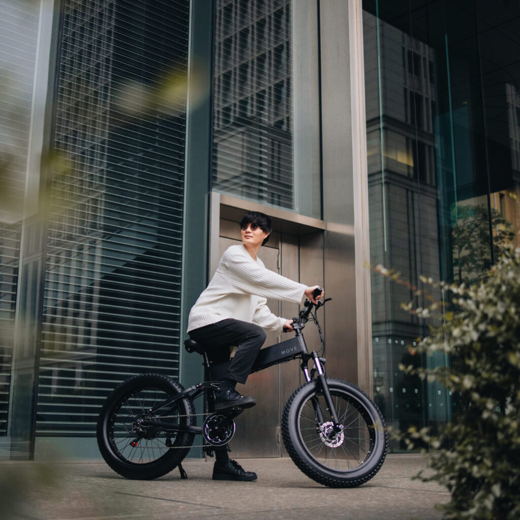 電動自転車MOVE 男性がビル前でまたがり、上を見上げる