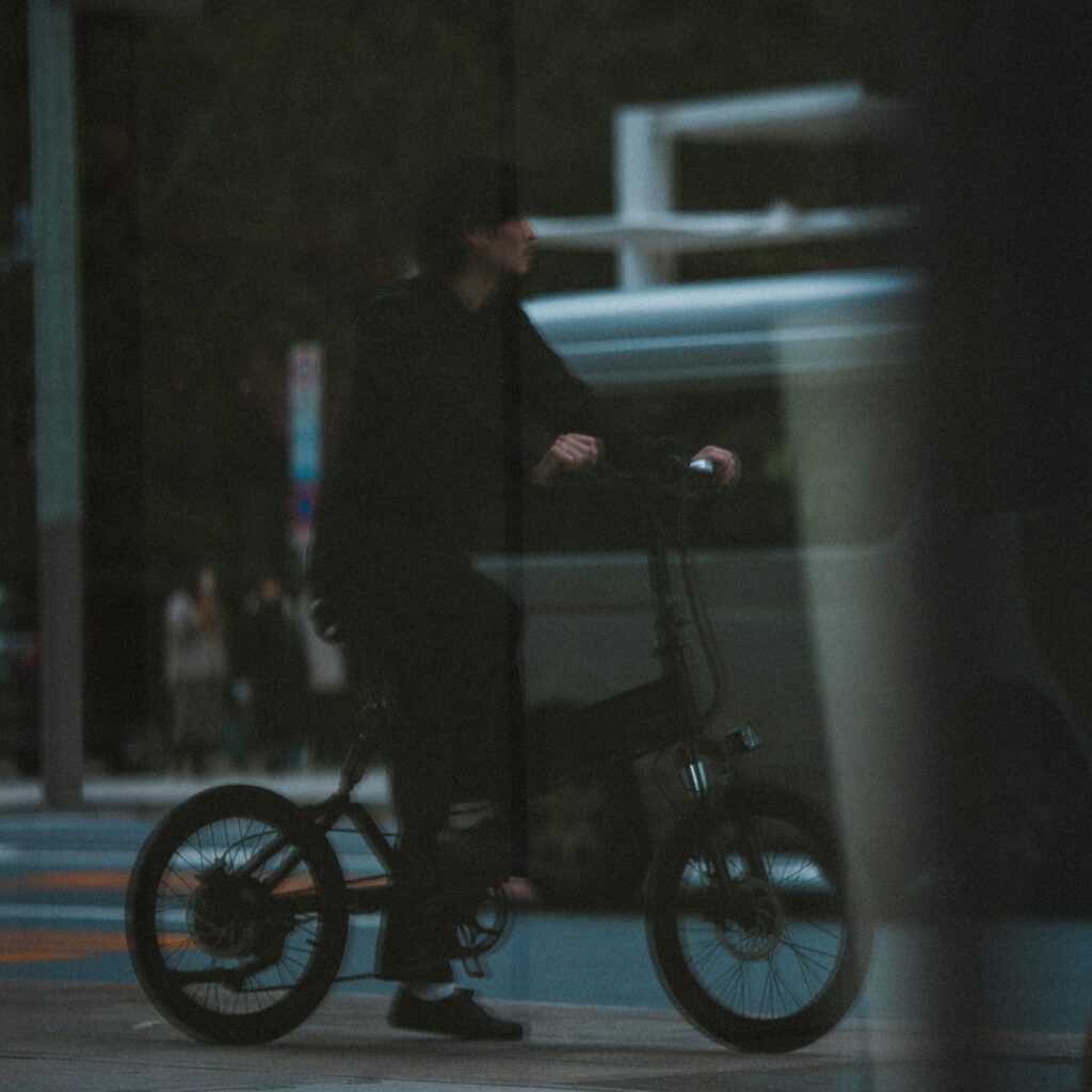 暗がりから電動自転車に乗っている男性が移っている様子