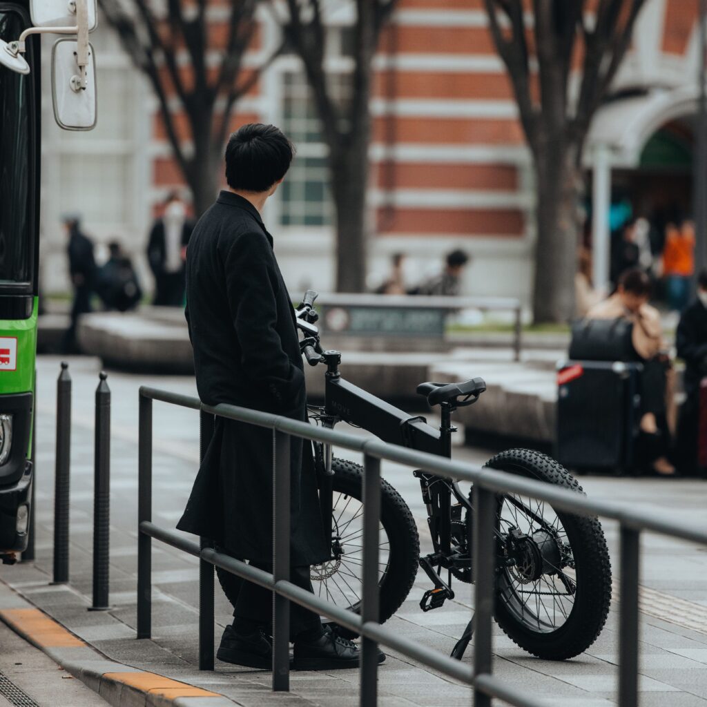 電動自転車MOVEと東京駅前で男性が誰かを待っている様子