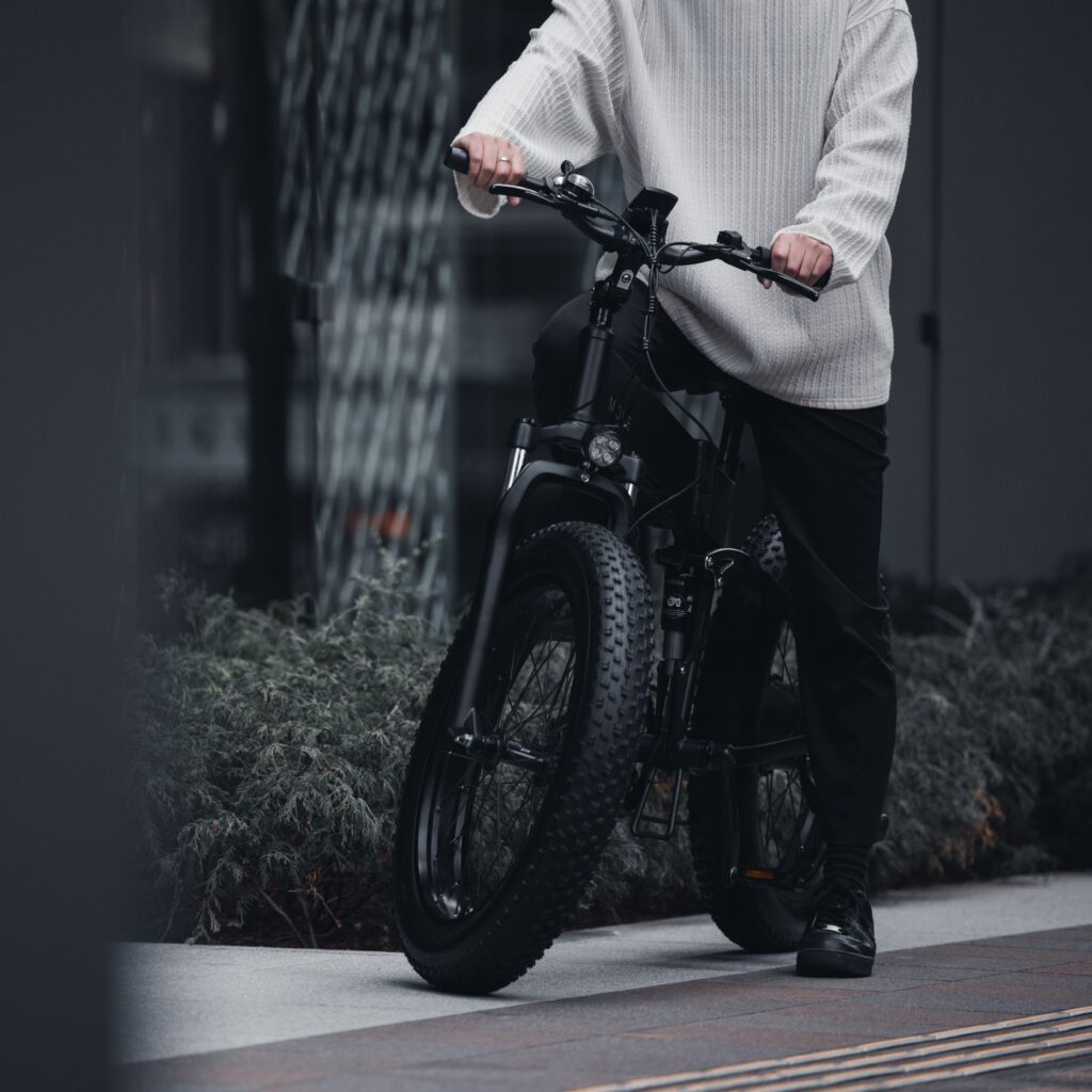 電動自転車を乗っている白服の男性が右側にいる