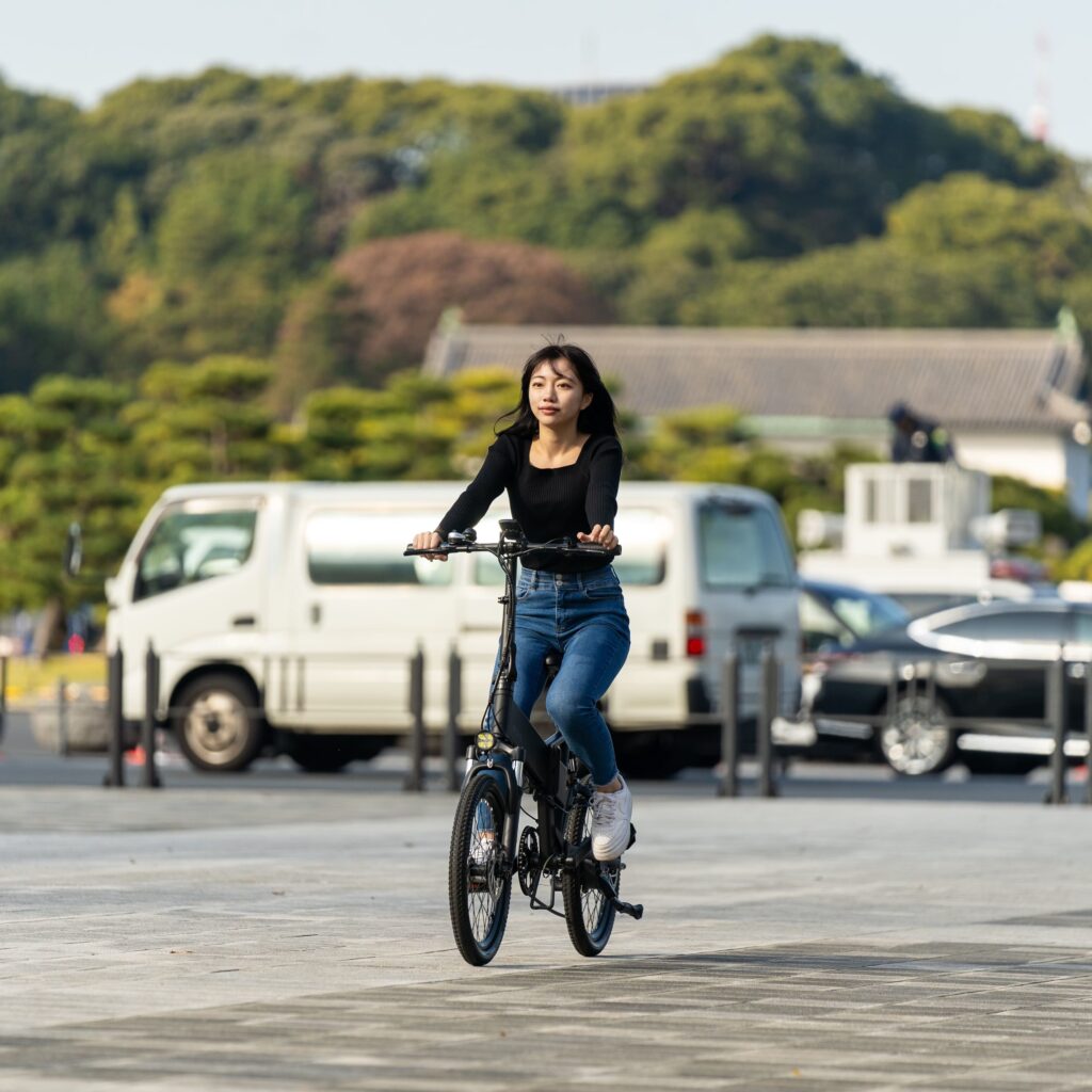 郊外の山付近で女性が電動自転車に乗っている様子