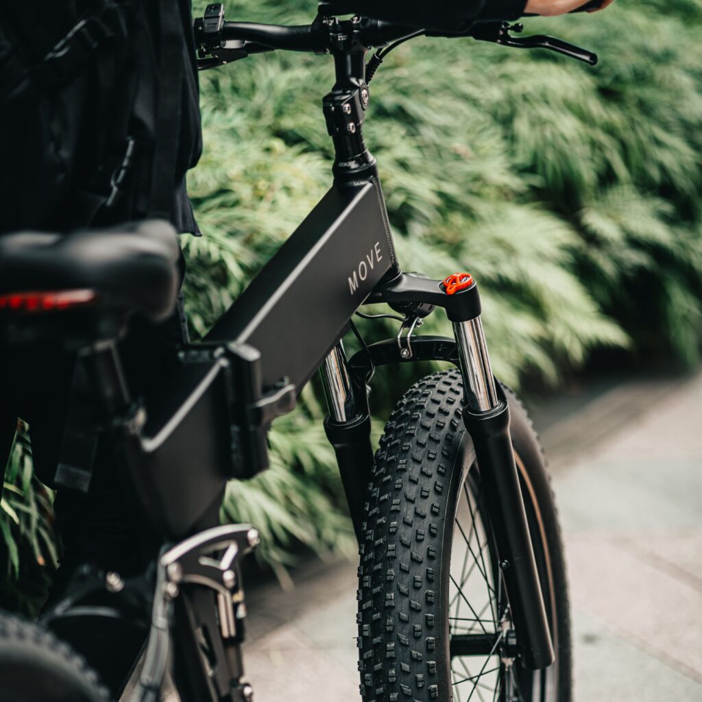 電動自転車を押しながら草の軒を歩いている