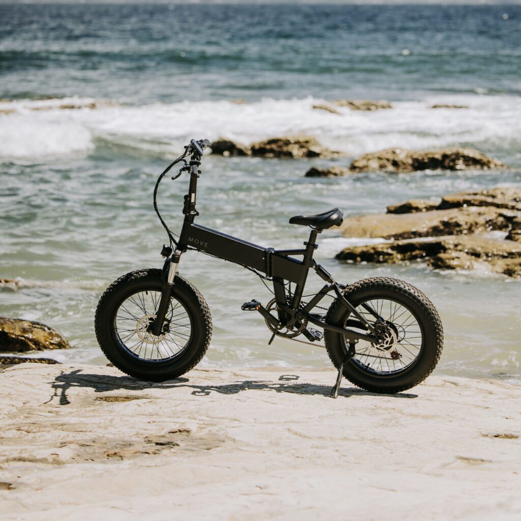 荒い大波をバックにたたずむ電動アシスト自転車